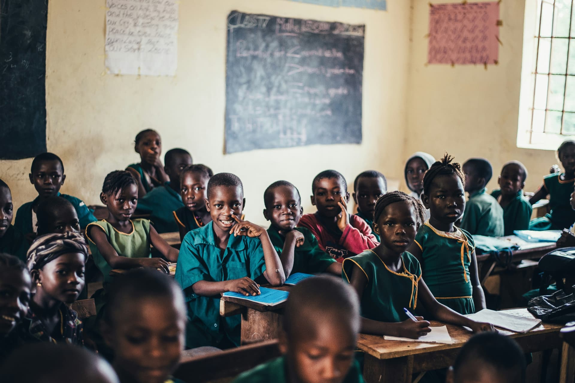 Students in green uniforms learning together in a classroom
